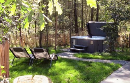 een achtertuin met twee stoelen en een grill in het gras bij Houtsnip in Ommen