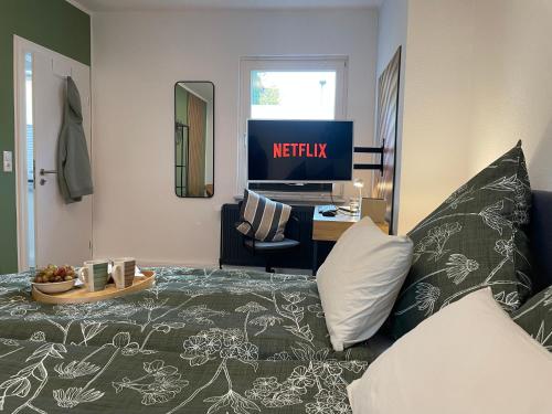 a living room with a bed and a desk with a television at Wolfsbutze - zentrales Motto Apartment in Verden