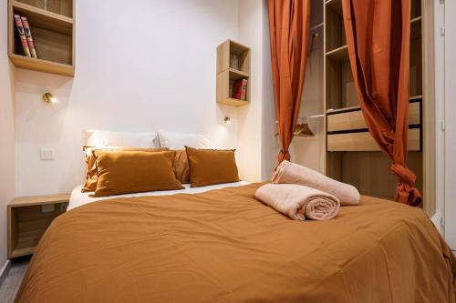 - une chambre dotée d'un grand lit avec des draps et des oreillers orange dans l'établissement Nice - Appartement central - 10 min de la plage, à Nice