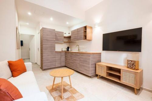 un salon avec un canapé, une télévision et une table dans l'établissement Nice - Appartement central - 10 min de la plage, à Nice
