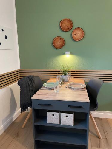 a table and two chairs with glasses on it at Wolfsbutze - zentrales Motto Apartment in Verden