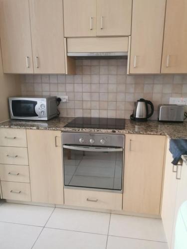 a kitchen with a stove and a microwave at Relax by the sea in Protaras