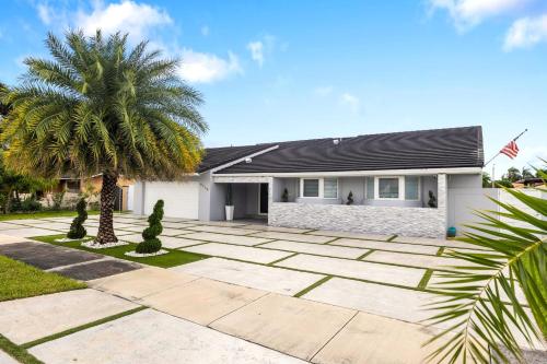 a house with a palm tree in front of it at Spectacular Miami 12 mil to Downtown 5Bedrooms Game Room Heated Pool in Tamiami