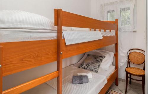 a bedroom with two bunk beds and a chair at 3 Bedroom Lovely Home In Susanj in Sušanj