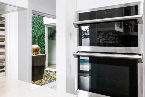 a kitchen with a microwave above a stove at Spectacular Miami 12 mil to Downtown 5Bedrooms Game Room Heated Pool in Tamiami