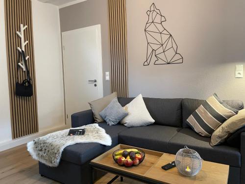 a living room with a couch and a table at Wolfsbutze - zentrales Motto Apartment in Verden
