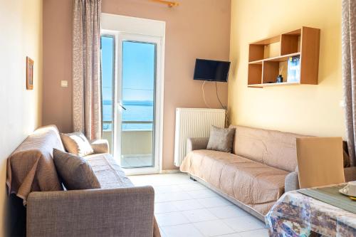 a living room with a couch and a view of the ocean at Angela Studios in Karfas