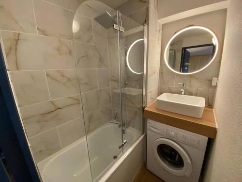 une salle de bain avec douche et lavabo et une machine à laver dans l'établissement Appartement T3 Saint Lary Soulan, à Vignec