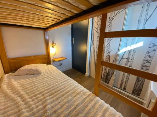une chambre avec un lit et une grande fenêtre dans l'établissement Appartement T3 Saint Lary Soulan, à Vignec