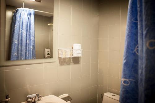 a bathroom with a sink and a toilet and a mirror at Pensión Ametzagaña in San Sebastián