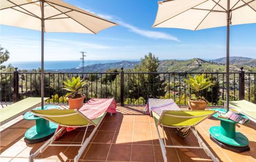 a patio with chairs and umbrellas on a balcony at 7 Bedroom Stunning Home In Frigiliana in Acebuchal