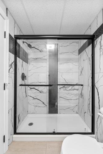 a bathroom with a shower with a tub at Green Harbor Hotel in Marshfield