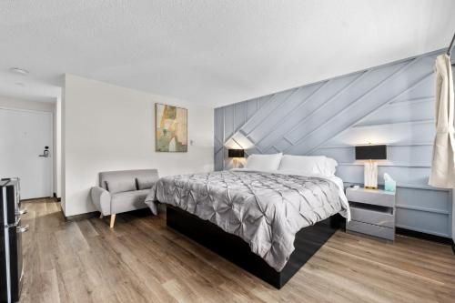 a bedroom with a large bed and a chair at Green Harbor Hotel in Marshfield