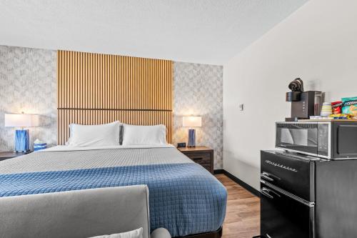 a hotel room with a bed and a microwave at Green Harbor Hotel in Marshfield