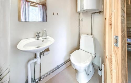 a bathroom with a toilet and a sink at Stuga 4 in Nybro