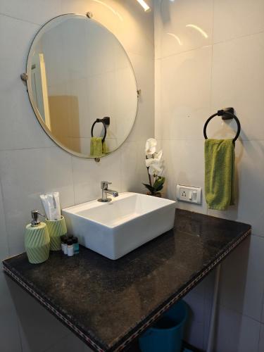 a bathroom with a white sink and a mirror at SOLS Backyard in Arambol