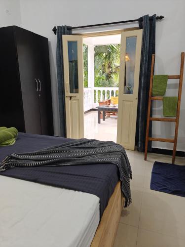 a bedroom with a bed and a sliding glass door at SOLS Backyard in Arambol