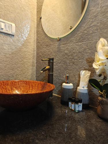 a bathroom with a copper sink and a mirror at SOLS Backyard in Arambol