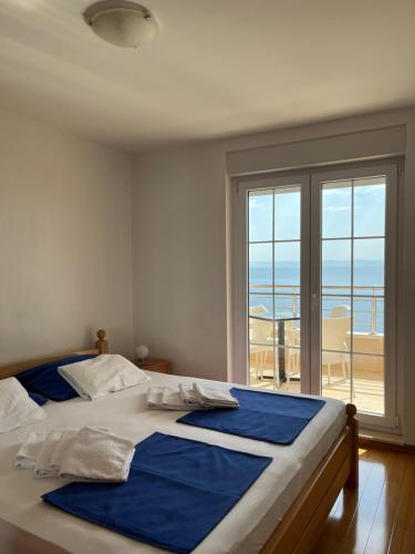 een slaapkamer met een bed met uitzicht op de oceaan bij Apartments KARLO in Baška Voda