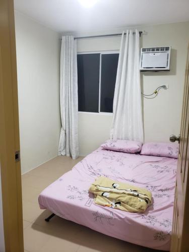 a small bedroom with two beds with purple sheets at Oceanview 2-bedroom Condo Unit in Dumaguete