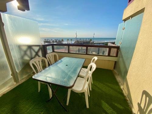 - un balcon avec une table et des chaises et la plage dans l'établissement Appartement idéalement situé face à l'océan, à Lacanau