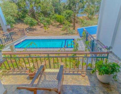 a balcony with benches and a swimming pool at Bungalow Resort - Sigiriya in Sigiriya