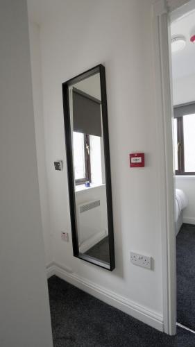 a mirror on a wall in a room at LuxuryInn in Wolverhampton