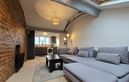 a living room with two couches and a brick wall at Stylish City Centre Apartment with Parking in Preston