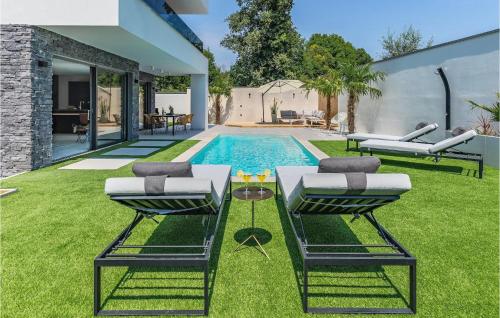 a backyard with a pool with two chairs and a table at Villa Bonaca in Medulin