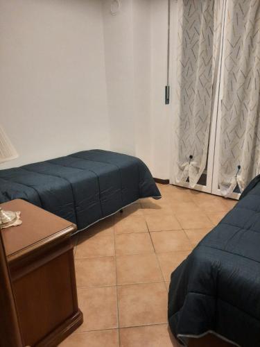 a room with two beds and a desk and a table at Casa vacanze le coccinelle in Nizza Monferrato