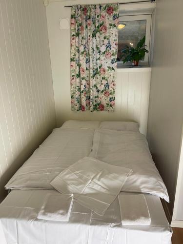 Posto letto in una piccola camera con finestra di Romslig hybel leilighet a Tromsø
