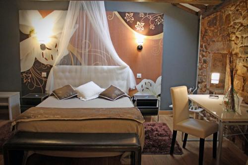 a bedroom with a bed and a table and a desk at Posada Ormas in Ormas