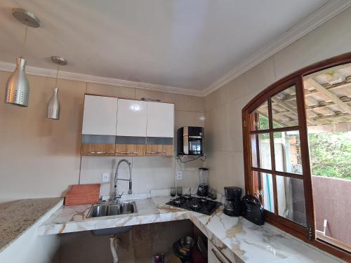 a kitchen with a sink and a counter top at Casa do sossego in Cabo Frio