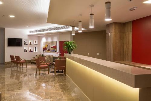 a lobby with a bar and a dining room at Sleep Inn Praia do Canto in Vitória