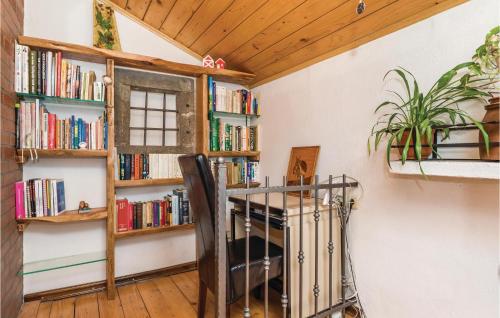 a room with a table and bookshelves with books at Holiday Home In Vele Mune in Vele Mune