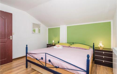 a bedroom with a bed and a green wall at Holiday Home In Vele Mune in Vele Mune