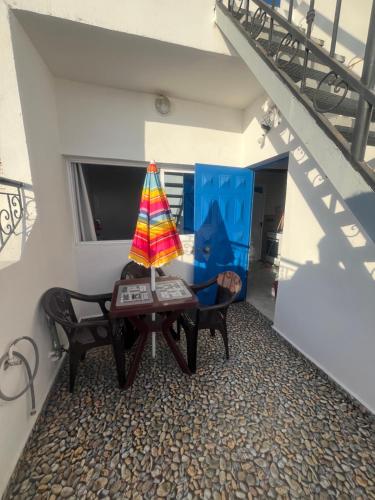 a living room with a table and chairs and a staircase at Sweet Taghazout Studios in Taghazout