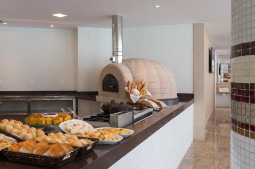 a kitchen with bread and pastries on a counter at Sleep Inn Praia do Canto in Vitória