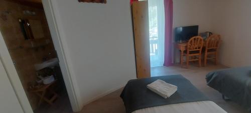 a bedroom with a bed and a table and a dining room at LES TOURISTES in Le Chatelard