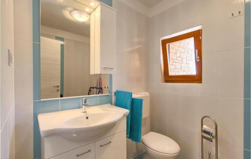a white bathroom with a sink and a toilet at Villa Ivka in Pula