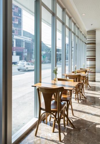 a row of tables and chairs in a room with windows at Sleep Inn Praia do Canto in Vitória