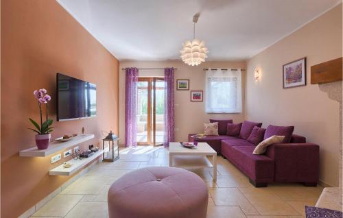 een woonkamer met een paarse bank en een tv bij Villa Emanuel in Pula