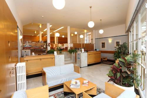 a lobby with a couch and tables and a kitchen at Hotel Genova in Sestri Levante