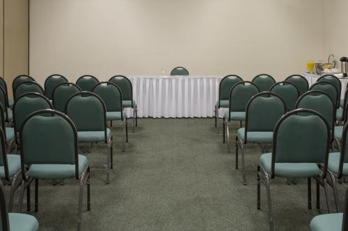 a conference room with green chairs and a table at Sleep Inn Praia do Canto in Vitória