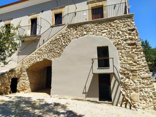 a building with an arch and a balcony at Antica Masseria Lo Conte in Ariano Irpino