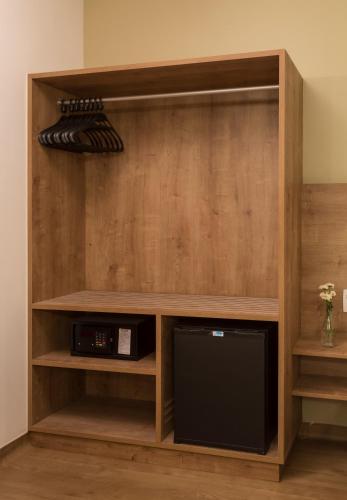 a book shelf with a tv in a room at Sleep Inn Praia do Canto in Vitória
