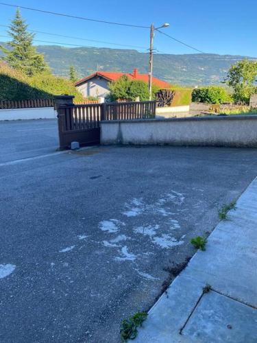 una strada vuota con una recinzione e una casa di Charmant appartement Entre lacs et montagnes ! a Culoz