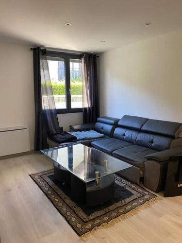 un salon avec un canapé et une table en verre dans l'établissement Charmant appartement Entre lacs et montagnes !, à Culoz