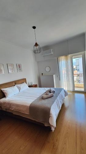a bedroom with a large bed and a large window at Antonia's city apartment in Ioannina