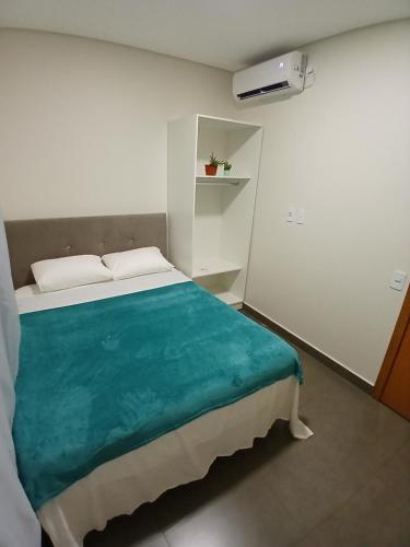 a bedroom with a large bed with a blue blanket at Iguassu Falls Refuge - Cataratas do Iguassu - Paraguai - Argentina in Foz do Iguaçu